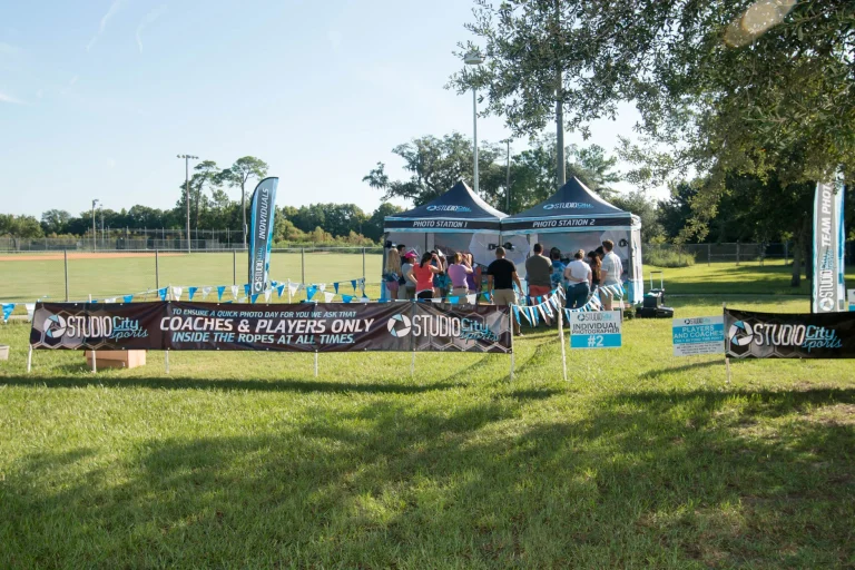Photo Day Cashier Station Setup For Youth Sports Photography By Studio City Sports With Check-In Booth, Banners, And Outdoor Field.
